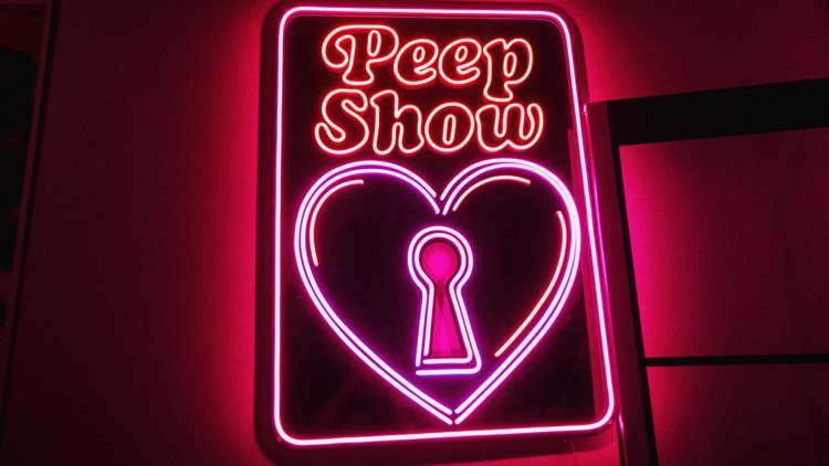 A neon sign that reads peep show