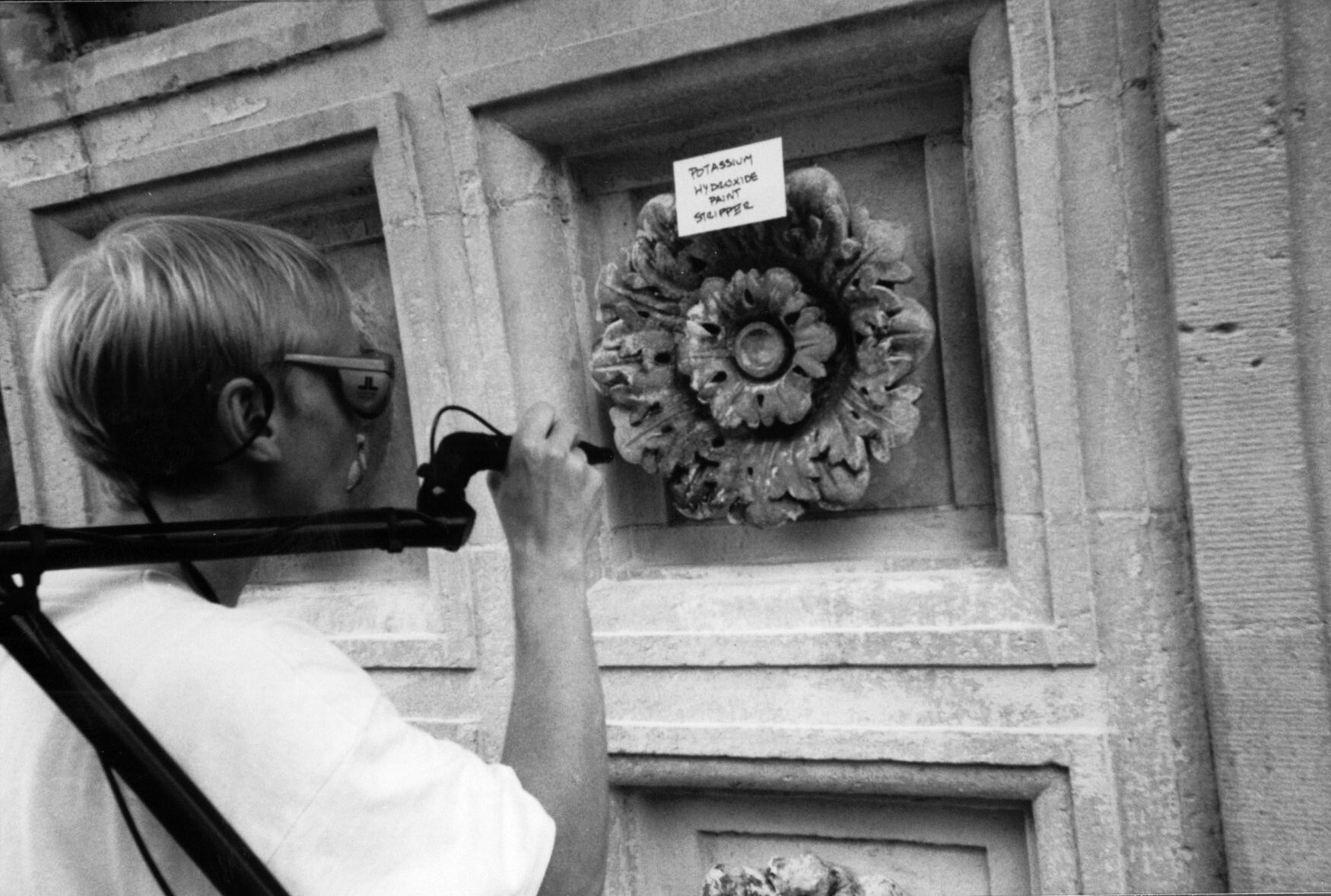 A worker cleans rosettes on the Washington Square Park arch.