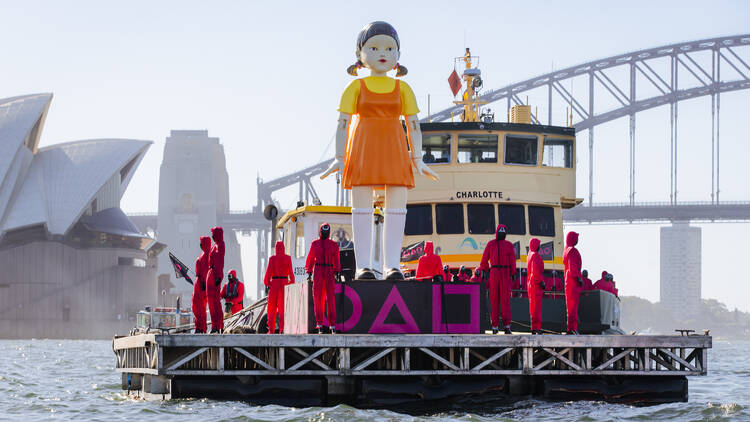 a giant doll transported across syd harbour