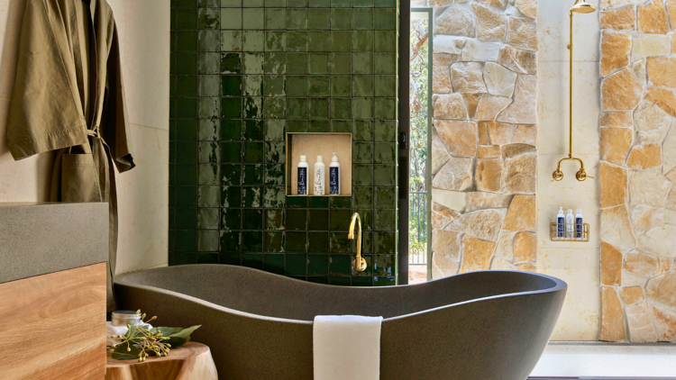 Green tiled bathroom with concrete tub