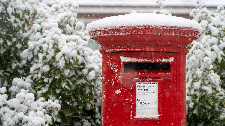 UK Royal Mail red postbox in the snow