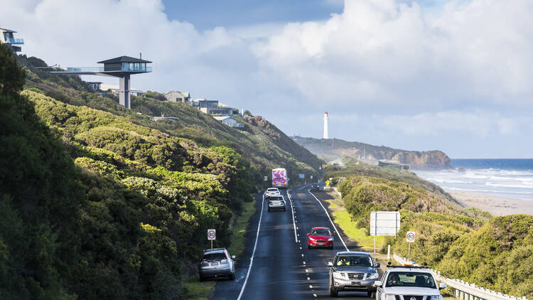 Cars driving on road next to coast