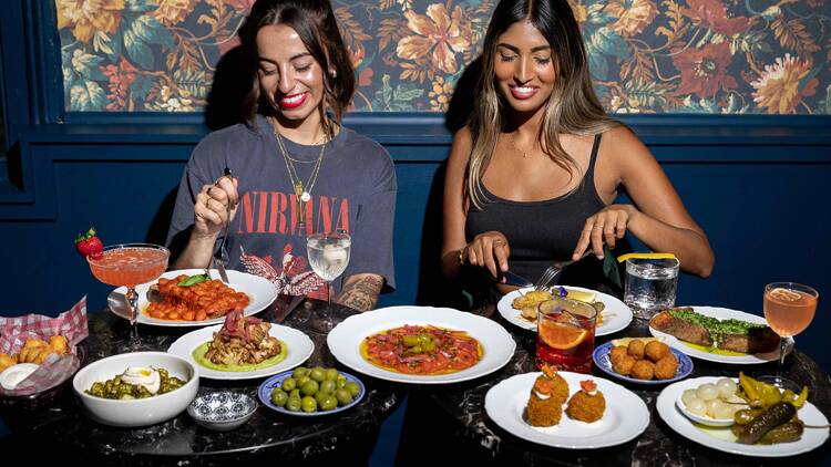 Two girls eating and drinking at Frankie Cadillac