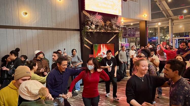 A group of people learn to dance the salsa.