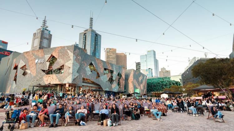 Punters gather in beach chairs at the Fed Square Outdoor Cinema