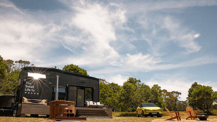 Tiny Home with yellow car parked beside