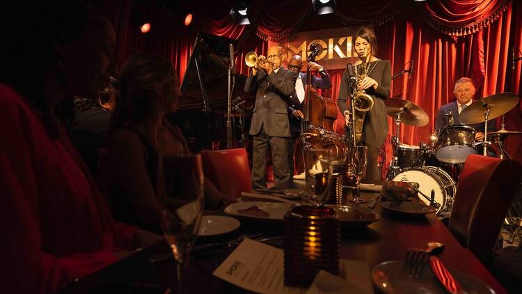 Musicians play jazz music inside a club.