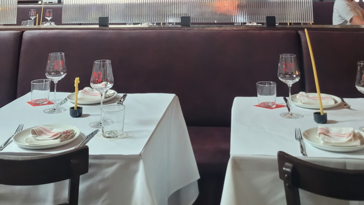 Two set tables with white tablecloths