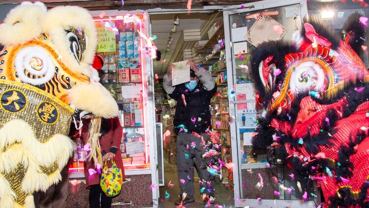 lion dancers in front of a business in Chinatown