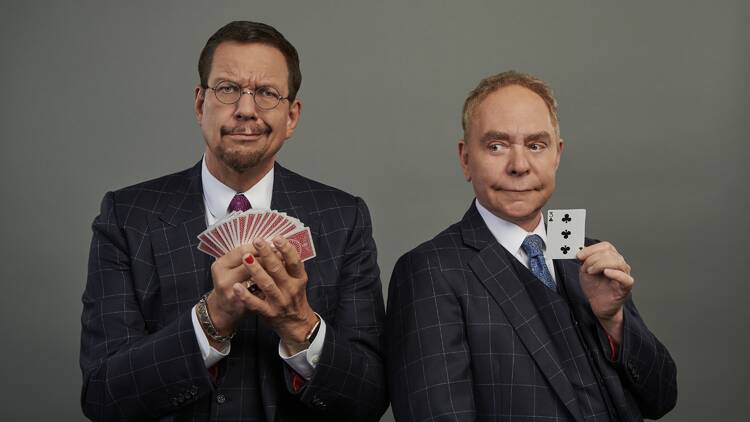 Two magicians holding cards