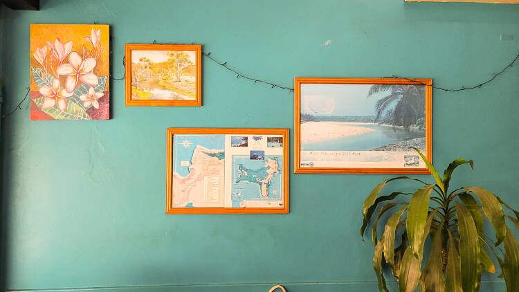 Framed photos on a aqua wall.