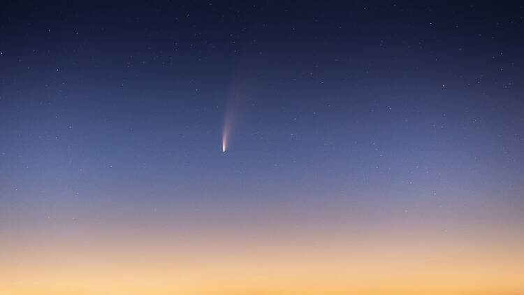 Comet flying through sky at sunset