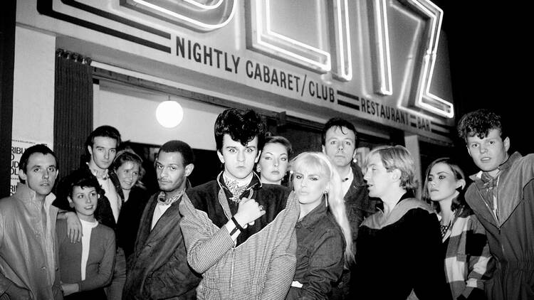 A crowd of flamboyantly dressed Blitz kids standing outside the famous Covent Garden Blitz club where New Romanticism was born