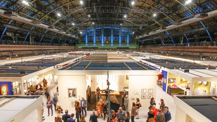 People look through exhibitor's booths at the Park Avenue Armory.