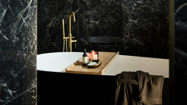 A luxe bath with a fancy gold tap