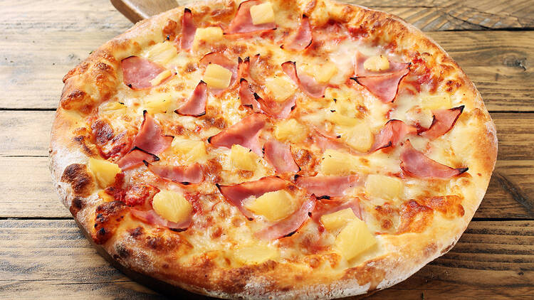 A hawaiian pizza with pineapple and ham