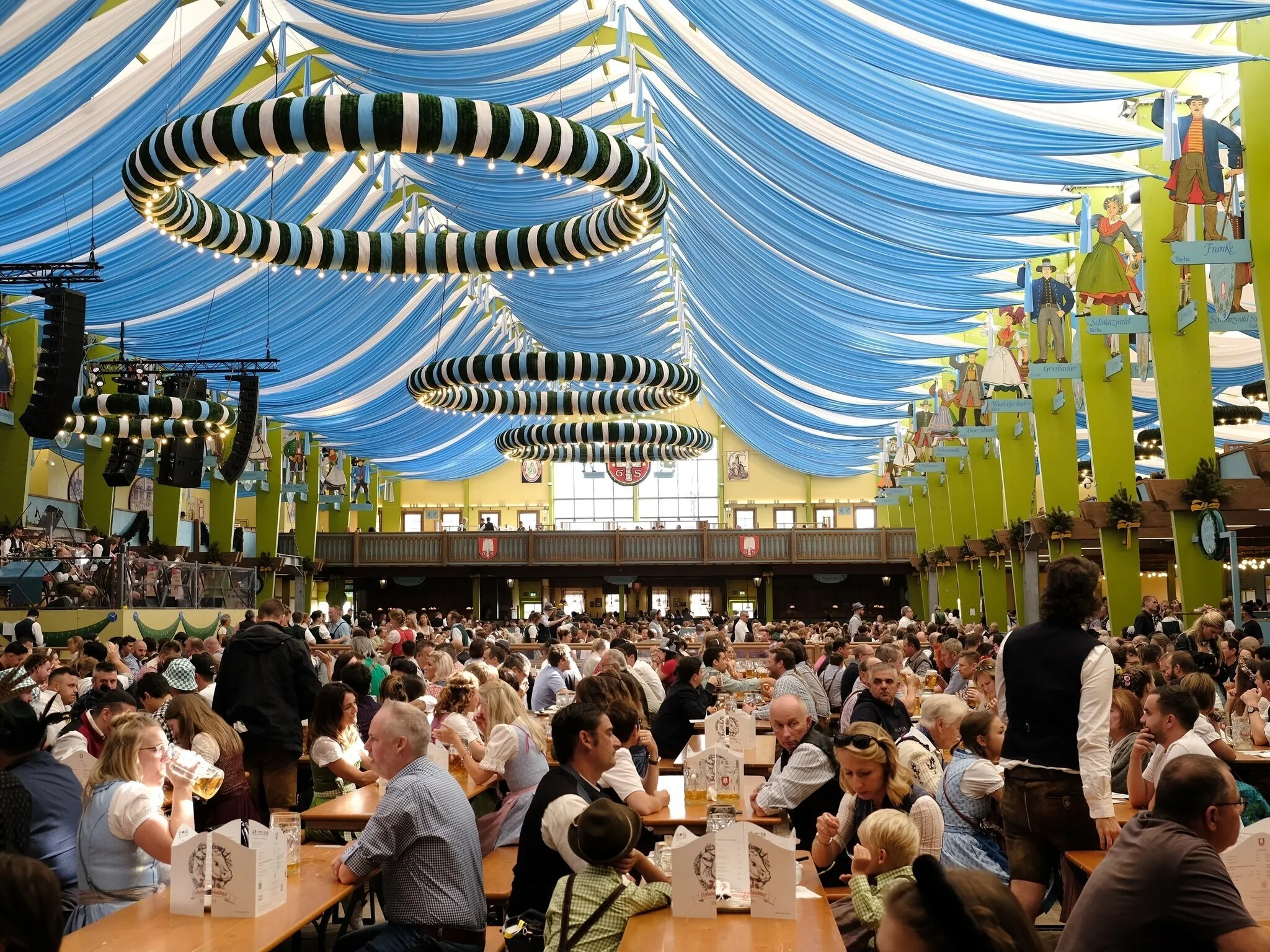 Munich, Germany - October 1, 2023. People relaxing inside the beer tent at Oktoberfest 2023, the world famous beer festival in the Bavarian culture called d' Wiesn, in Munich, Deutschland.