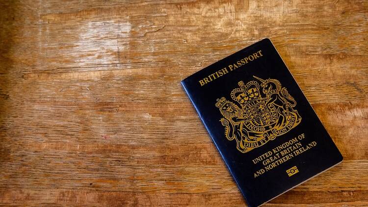 A navy blue British passport on a wooden background