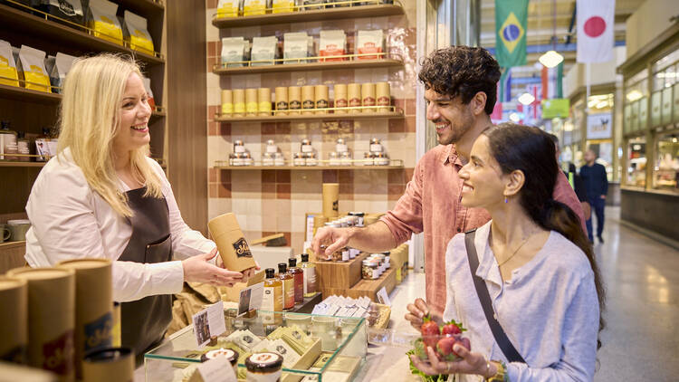 Two people buying products from a stall 