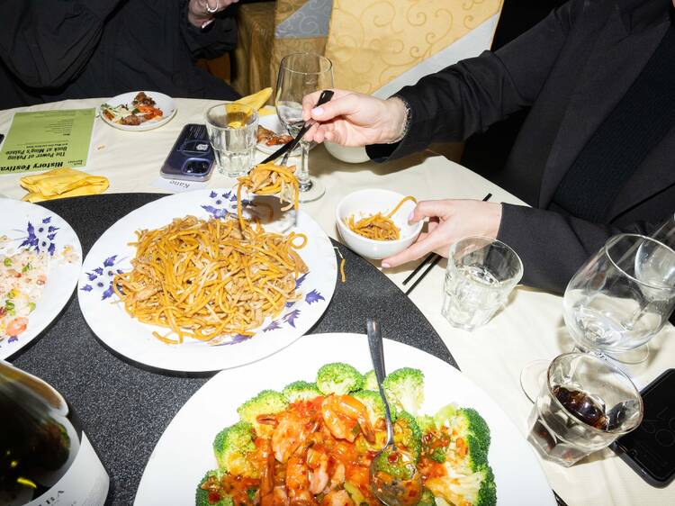 Chinese food spread with noodles and broccoli dishes