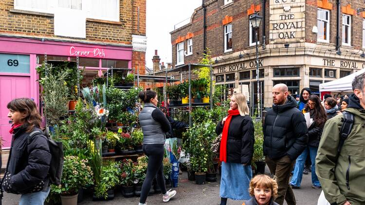 Crowds of people walk past a flower stall outside the Royal Oak pub on Columbia Road 