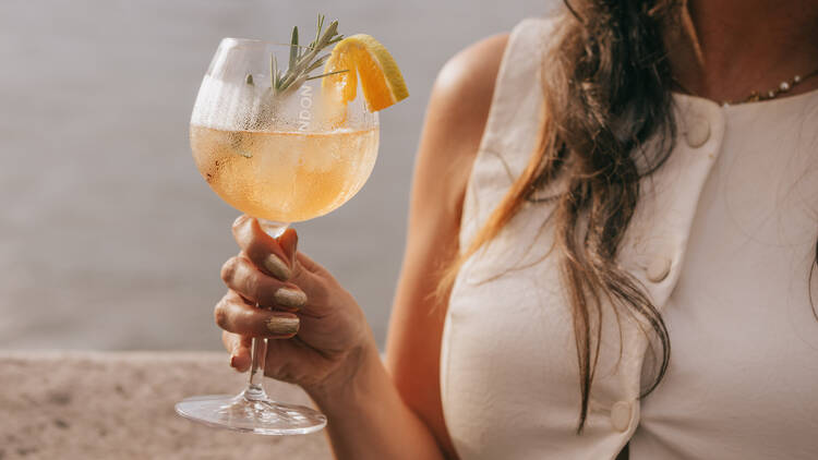 A woman holding a spritz