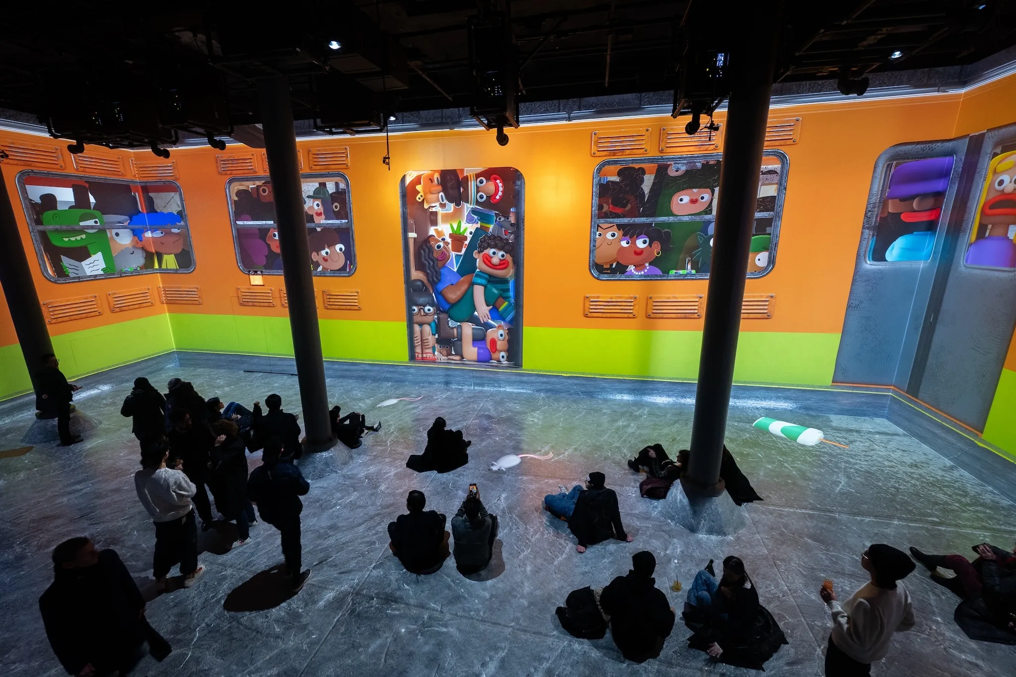 Large digital art of a packed subway train is projected on the walls.