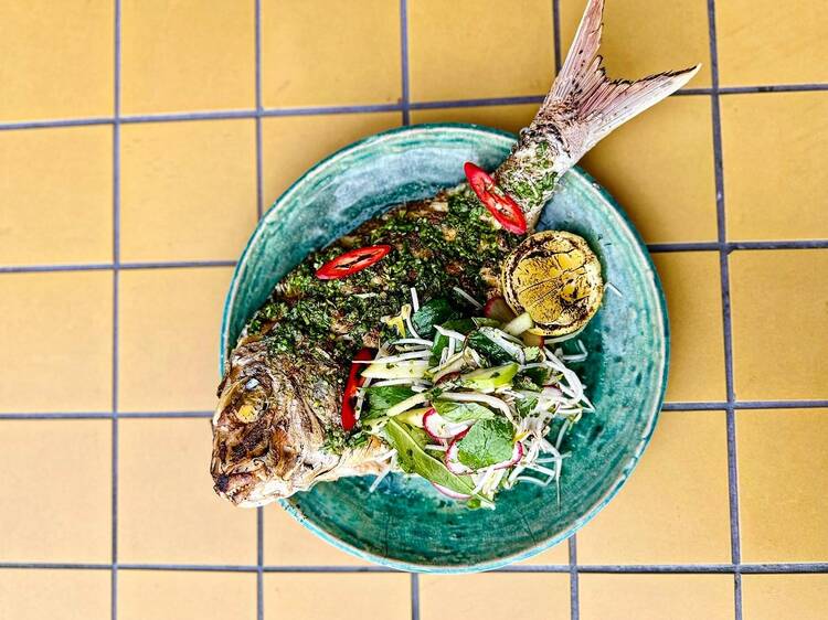 Whole cooked fish on blue plate