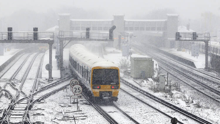 Snow on railway tracks and train in the UK in winter