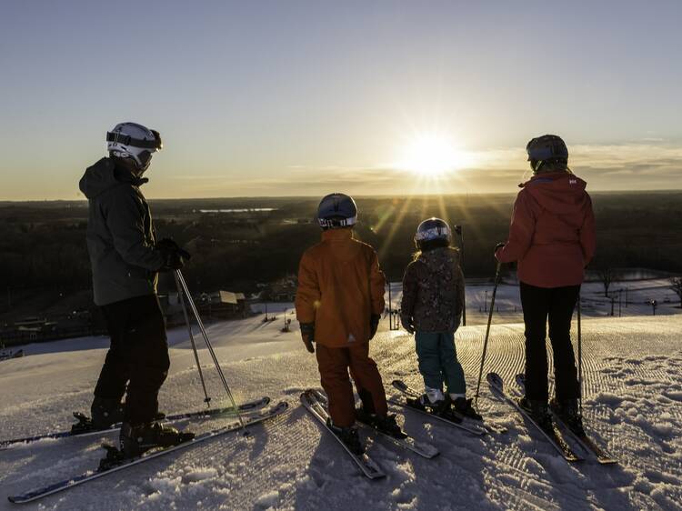 Family skiing together during sunrise at Wilmot Mountain