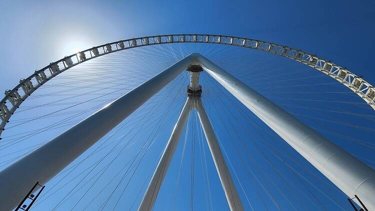 The London Eye from below with sunny clear blue sky behind. 