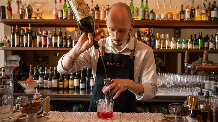 A bartender pouring a cocktail at Bar Olo.