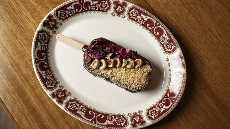 A chocolate and hazelnut ice cream on a decorated plate.