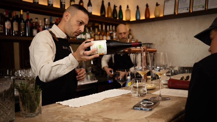 A bartender pouring wines at Bar Olo.