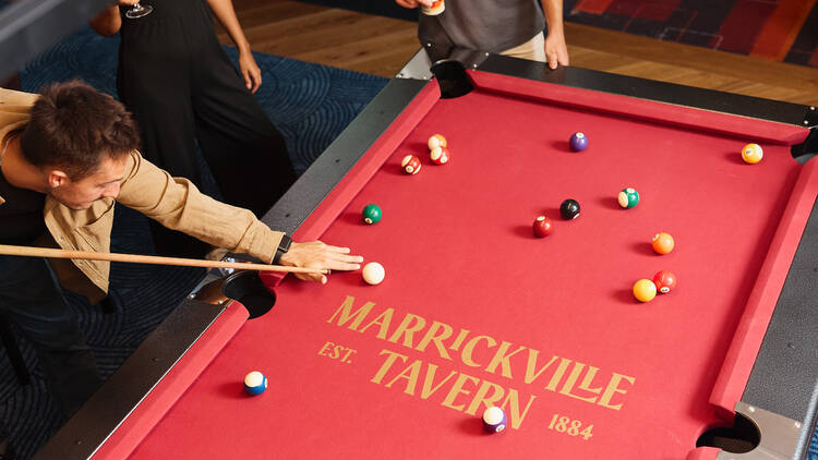 A pool table with people playing 