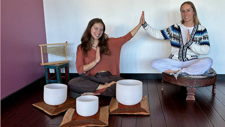 Two people sitting with singing bowls Two people sitting with singing bowls