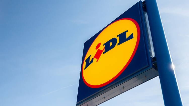 Lidl sign on blue pole set against clear blue skies. 