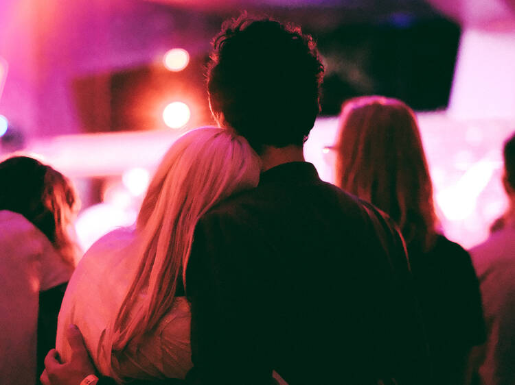 A couple standing together watching a performance. 