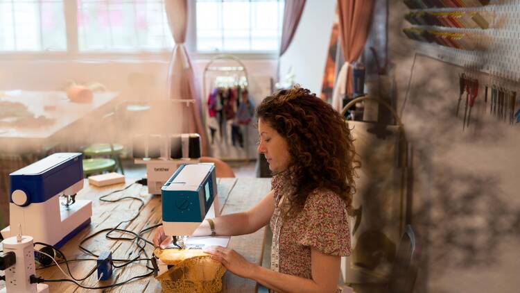 A woman works at a sewing machine.