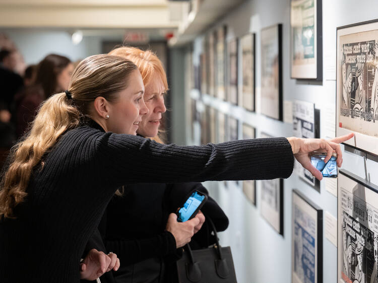 Two women look at art.