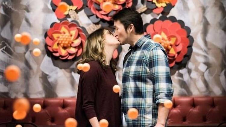 two people kissing in front of ping pong table two people kissing in front of ping pong table