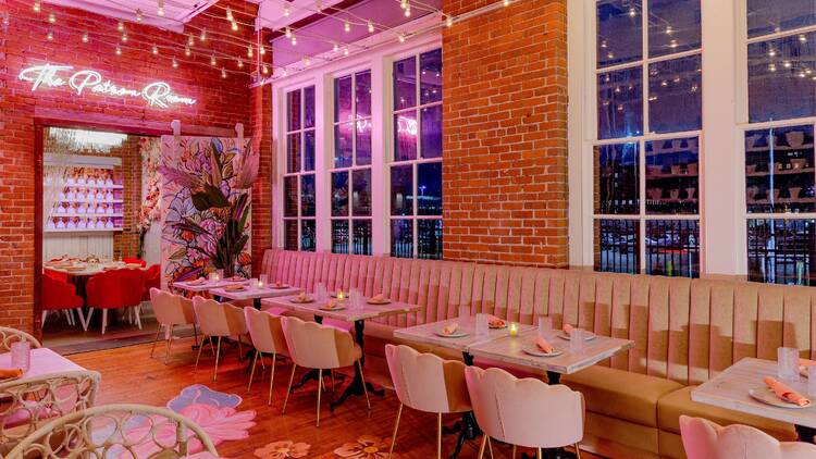 restauarant interior with banquette seating and pink lighting