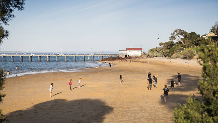 Kids playing cricket on Cowes Beach in Phillip Island.