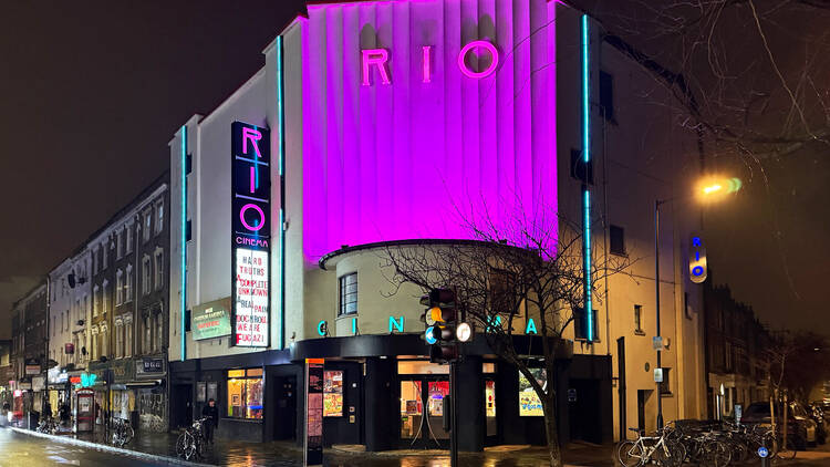 Exterior of Rio Cinema in Dalston at night, illuminated with purple light