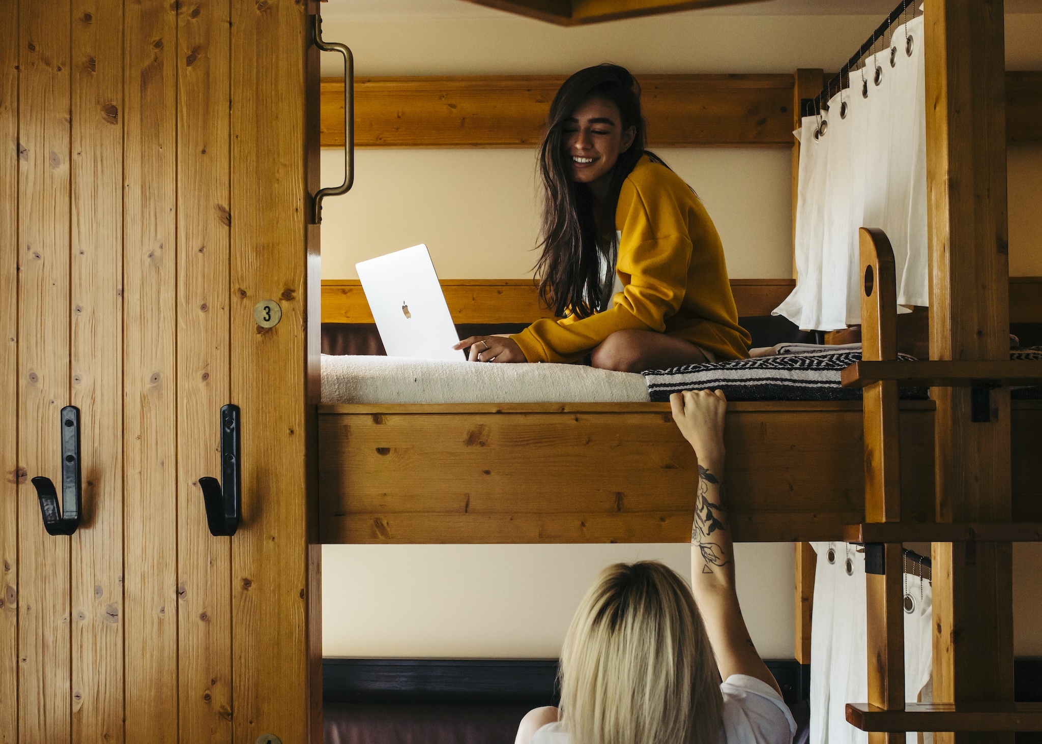 Two people in bunk beds in a hotel room.