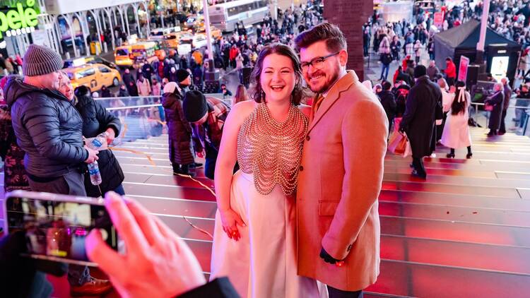 A couple poses for a photograph after a vow renewal in Times Square.