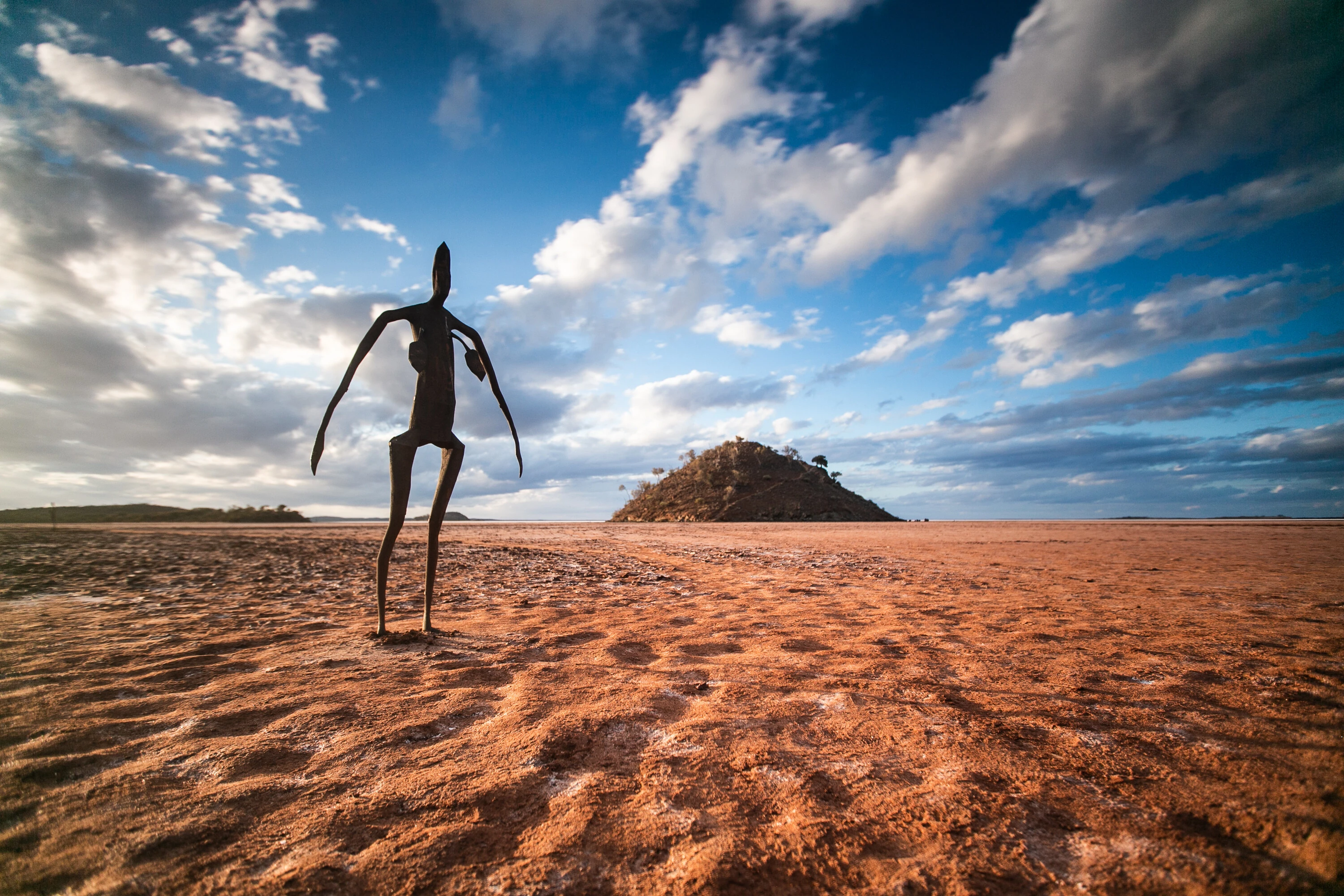 Human sculpture on sand in desert