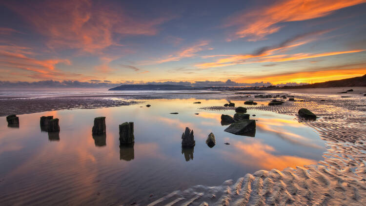 Beach with water reflecting a sunset 