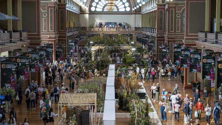 The Royal Exhibition Building filled with people and plants. 