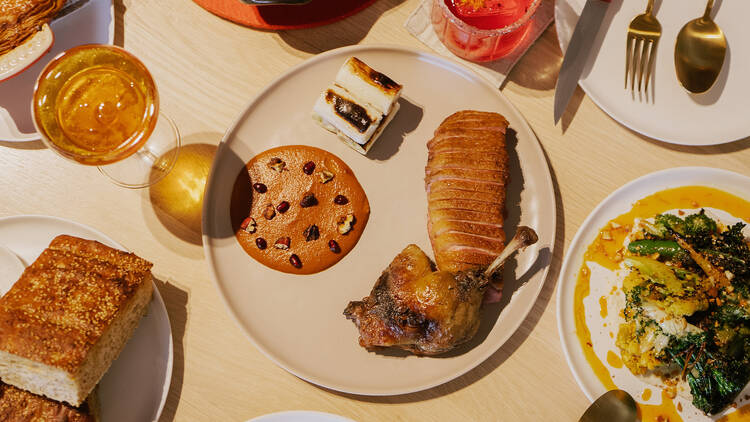 The dry-aged duck with mole (center), barbari bread (bottom left) and seasonal vegetable ajoblanco (bottom right) 